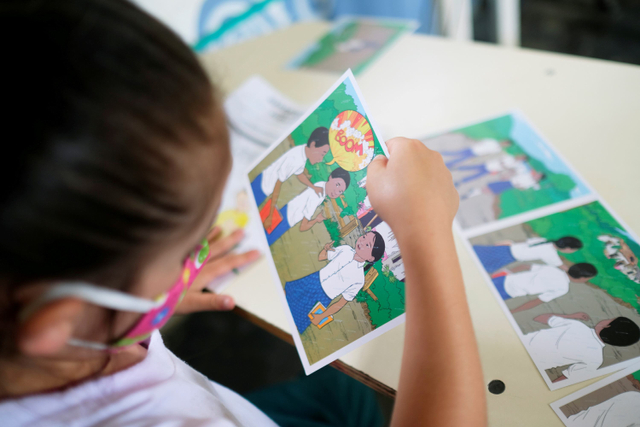 Seorang anak melihat poster cara mengidentifikasi ranjau anti-personil di Carmen de Viboral, Kolombia. Foto: Santiago Mesa/REUTERS