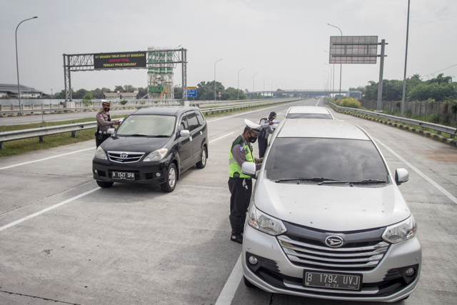 Polisi dan petugas Dishub memeriksa dokumen syarat melakukan perjalanan pengemudi di Pintu Tol Colomadu, Karanganyar, Jawa Tengah, Kamis (22/7/2021). Foto: Mohammad Ayudha/Antara Foto