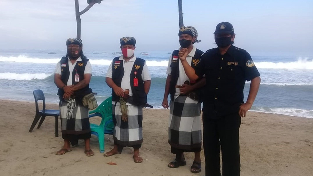 Petugas keamanan desa adat melakukan pengawasan kegiatan di Pantai Kuta, Bali - IST