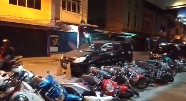Pria diduga sedang mabuk menginjak-injak mobil milik pengunjung hotel. Foto: Istimewa