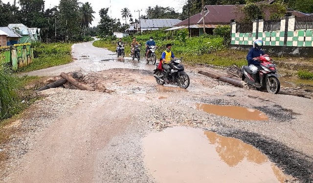 Sejumlah pengendara berusaha menghindari lubang yang dipenuhi air akibat jalan rusak yang menghubungkan Kendari-Konsel. Foto: Sunarianto.