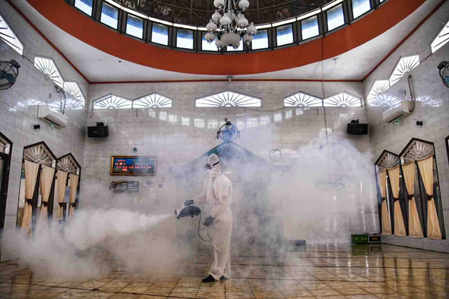 Petugas menyemprotkan disinfektan di Masjid Taqwa Muhammadiyah, Medan Denai, Medan, Sumatera Utara, Jumat (23/7/2021). Foto: Fransisco Carolio/ANTARA FOTO