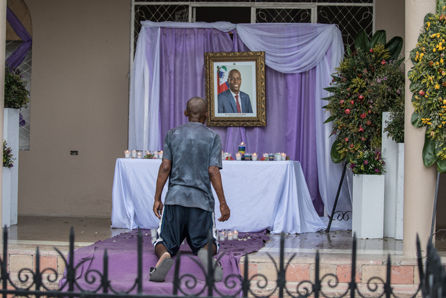 Seorang pria berdoa di depan tugu peringatan untuk Presiden Jovenel Moise yang dipasang di dekat Katedral Our Lady of the Assumption di Cap-Haitien. Foto: Valerie Baeriswyl / AFP