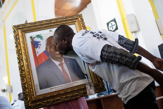 Warga mencium foto Presiden Haiti Jovenel Moise yang terbunuh. Foto: REUTERS/Ricardo Arduengo