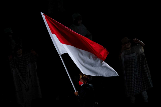 Peselancar Indonesia Rio Waida membawa bendera Merah-Putih saat defile pembukaan Olimpiade Tokyo 2020 di Stadion Nasional Jepang,Tokyo, Jepang, Jumat (23/7/2021). Foto: Sigid Kurniawan/ANTARA FOTO