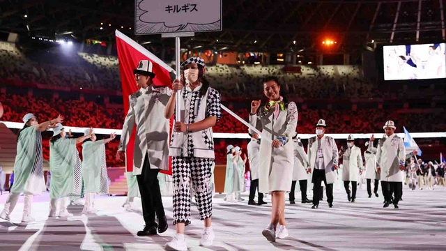 Pembawa bendera Kanykei Kubanychbekova dari Kirgistan dan Denis Petrashov dari Kirgistan memimpin kontingen mereka selama parade atlet pada upacara pembukaan Olimpiade 2020 Tokyo. Foto: Kai Pfaffenbach/REUTERS