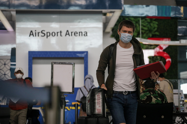 Warga Negara Asing berjalan menuju loket validasi dokumen penerbangan di area Terminal 3 Bandara Internasional Soekarno Hatta, Banten, Jumat (23/7/2021). Foto: Fauzan/Antara Foto