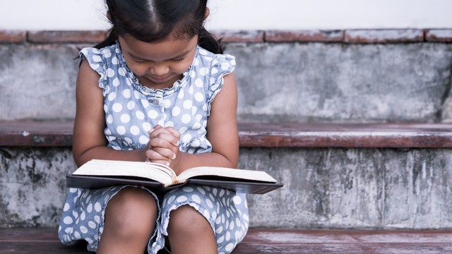Ilustrasi anak Kristen berdoa dengan Alkitab. Foto: Shutter Stock