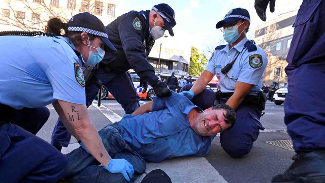 Polisi menangkap pengunjuk rasa yang berdemonstrasi menentang perintah tinggal di rumah selama sebulan di Sydney, Sabtu (24/7/2021). Foto: STEVEN SAPHORE/AFP