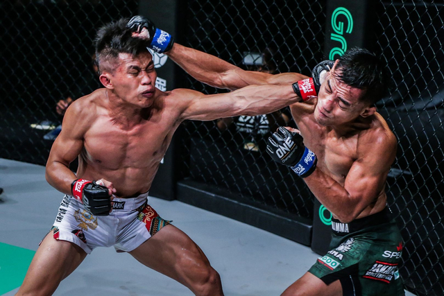 Stefer Rahardian (kanan) menghindari pukulan sembari melayangkan serangan pada Adrian Mattheis dalam laga MMA divisi strawweight pada Oktober 2019. Foto: ONE Championship