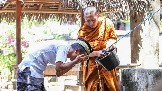 Foto seorang bhikkhu sedang membantu pria berwudu. Sumber: Dok. Ivan Mardiansyah