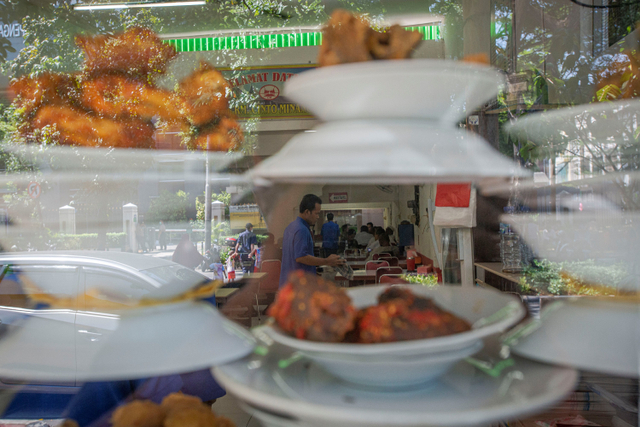 Pelayan warung makan melayani pelanggan di Kemayoran, Jakarta, Senin (26/7).  Foto: Aditya Pradana Putra/ANTARA FOTO