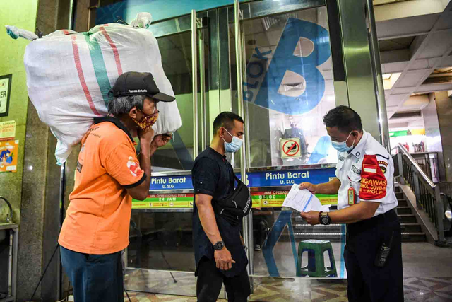 Petugas memeriksa kartu vaksinasi seorang pedagang yang akan memasuki Blok B Pasar Tanah Abang, Jakarta, Senin (26/7/2021). Foto: Hafidz Mubarak A/ANTARA FOTO