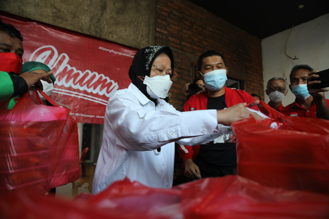 Menteri Sosial (Mensos) RI, Tri Rismaharini membantu distribusi makanan di salah satu dapur umum Kemensos. Foto: Kemensos.