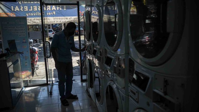 Pekerja mengoperasikan mesin cuci di sebuah jasa laundry di Jalan Dipatiukur, Bandung, Jawa Barat, Senin (26/7/2021). Foto: Raisan Al Farisi/ANTARA FOTO