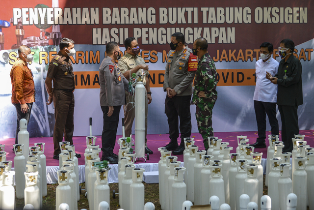 Gubernur DKI Jakarta Anies Baswedan (keempat kiri) didampingi Kapolda Metro Jaya (ketiga kiri), Pangdam Jaya (ketiga kanan) saat penyerahan tabung oksigen. Foto: M Risyal Hidayat/Antara Foto