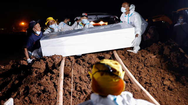 Petugas memakamkan jenazah COVID-19 di pemakaman khusus COVID-19 . Foto: Willy Kurniawan/REUTERS