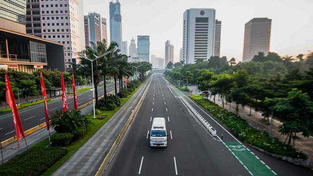 Sebuah mobil ambulans melintas saat berlangsungnya Pemberlakuan Pembatasan Kegiatan Masyarakat (PPKM) Darurat di kawasan Jenderal Sudirman, Jakarta. Foto: M RISYAL HIDAYAT/ANTARA FOTO