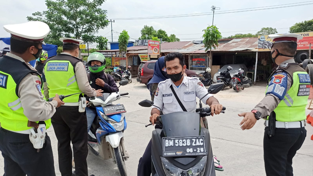 ANGGOTA Polisi meminta warga hendak masuk Kota Pekanbaru untuk putar balik karena tak memenuhi syarat ditentukan peraturan. 