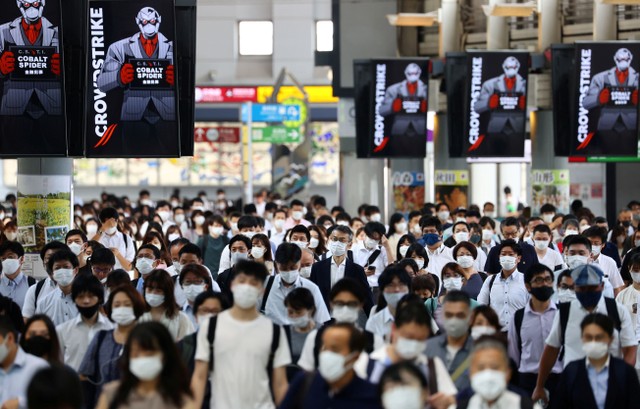 Para penumpang yang mengenakan masker berjalan di stasiun Shinagawa di Tokyo, Jepang. Foto: Kim Kyung-Hoon/Reuters