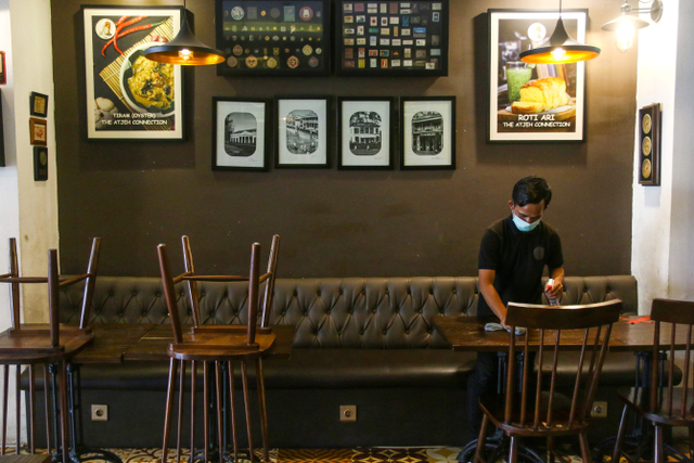 Pekerja membersihkan salah satu restoran di Jakarta, Kamis (29/7/2021). Foto: Rivan Awal Lingga/Antara Foto