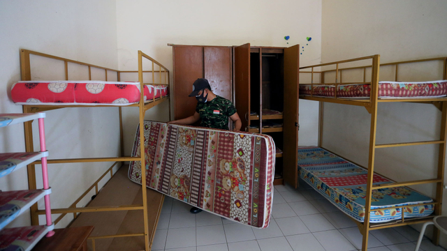 Personel Kodim 0808/Blitar menyiapkan perlengkapan di kamar Isolasi Terpadu di gedung asrama mahasiswa Fakultas Ilmu Pendidikan (FIP) Universitas Negeri Malang (UM), Kota Blitar, Jawa Timur, Jumat (30/7/2021). Foto: Irfan Anshori/ANTARA FOTO