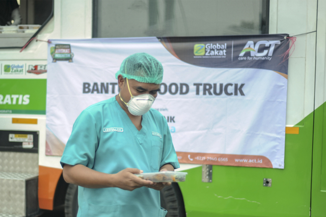 Seorang perawat di RSU Tangsel menerima sepaket makanan siap saji yang dibagikan ACT dari Humanity Food Truck, Jum'at (30/7). Foto: Faisal R Syam/PFI Tangerang