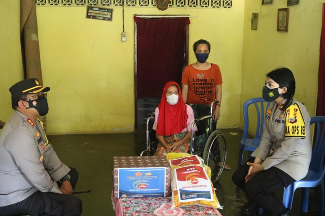 Kapolres Lampung Timur saat menyalurkan bantuan di kediaman Herawati, wanita lansia dala keadaan lumpuh yang tak mendapatkan bansos di masa PPKM, Sabtu (31/7) | Foto : Ist