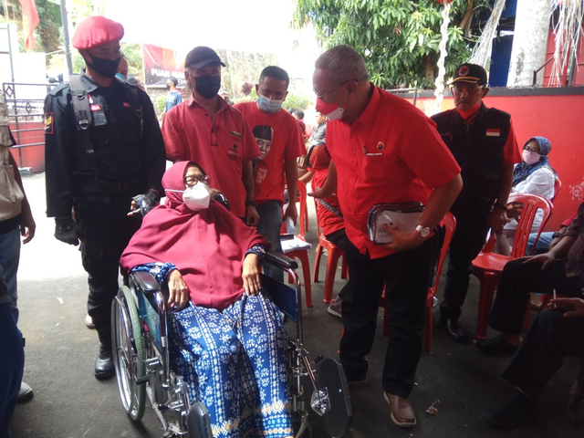 Ketua DPC PDIP Kuningan, Jawa Barat, H Acep Purnama SH MH saat menghampiri seorang warga yang ingin menjalani Vaksinasi Corona. (Andri)