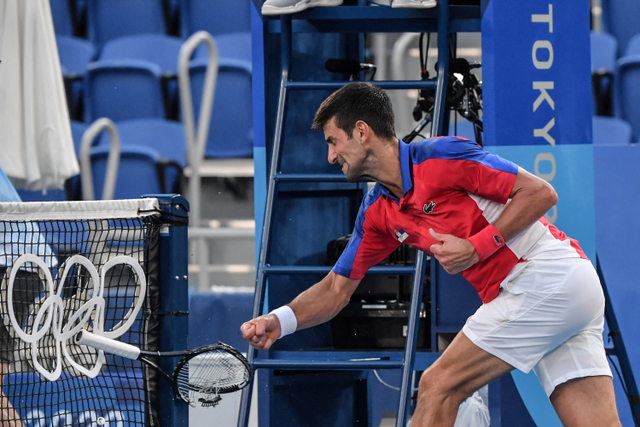 Petenis Serbia Novak Djokovic menghancurkan raketnya usai kalah dari petenis Spanyol Pablo Carreno Busta pada pertandingan perebutan medali perunggu Olimpiade Tokyo 2020 di Ariake Tennis Park, Tokyo, Jepang.  Foto: Tiziana FABI / AFP