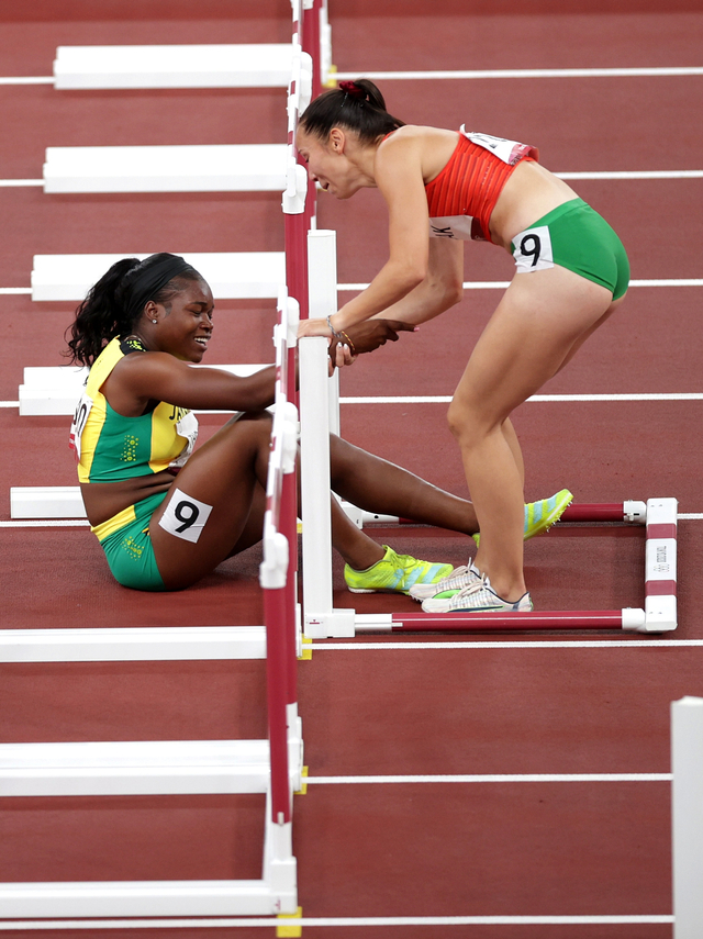 Atlet Hongaria, Luca Kozak, menolong atlet Jamaika, Yanique Thompson, di cabor halang rintang 100 meter putri  Foto: REUTERS/Hannah McKay