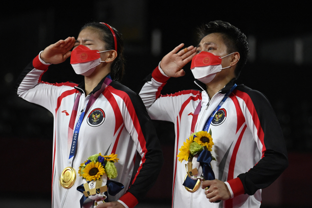 Atlet Indonesia Apriyani Rahayu (kanan) dan Greysia Polii Indonesia menangis usai berhasil 
mendapatkan medali emas bulu tangkis ganda putri pada upacara Olimpiade Tokyo 2020. Foto: Alexander Nemenov / AFP