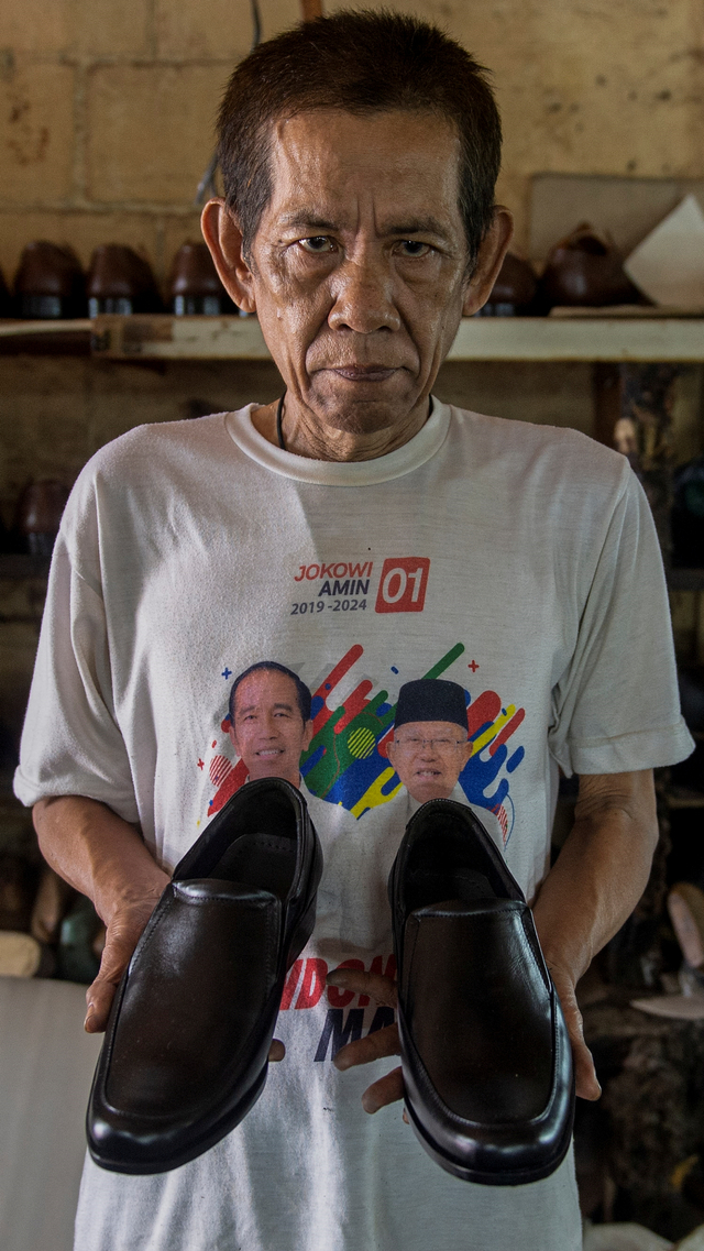 Pekerja menunjukkan sepatu yang telah jadi di bengkel kerja pembuatan sepatu milik Ardian di Perkampungan Industri Kecil (PIK) Penggilingan, Cakung, Jakarta Timur, Senin (2/8/2021). Foto: M Risyal Hidayat/ANTARA FOTO