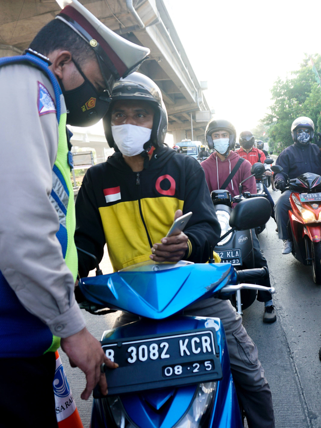 Polisi mengecek surat milik masyarakat di pos penyekatan pertigaan Lampiri, Kalimalang, Jakarta Timur. Foto: Iqbal Firdaus/kumparan