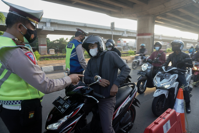 Polisi mengecek surat milik masyarakat di pos penyekatan pertigaan Lampiri, Kalimalang, Jakarta Timur. Foto: Iqbal Firdaus/kumparan