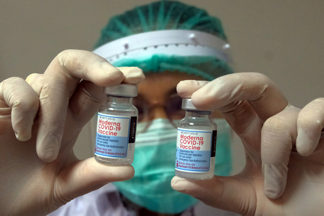 Petugas kesehatan menunjukkan vaksin Moderna saat vaksinasi COVID-19 dosis ketiga di Rumah Sakit Bali Mandara, Denpasar, Bali, Rabu (4/8).  Foto: Nyoman Hendra Wibowo/ANTARA FOTO
