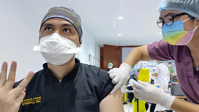 Seorang tenaga kesehatan di RSUP Prof Kandouw mengangkat tiga jari yang menandakan dirinya telah disuntik vaksin corona ke-3