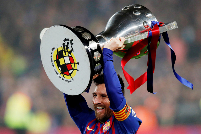 Pemain Barcelona Lionel Messi merayakan kemenangan La Liga dengan trofi pada 27 April 2019. Foto: Albert Gea/REUTERS