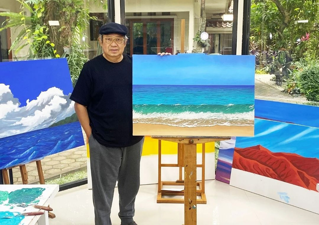 Susilo Bambang Yudhoyono (SBY) menunjukkan hasil lukisan karyanya berjudul 'Debur Ombak di Pantai Pacitan'. Foto: Instagram/andi_a_mallarangeng