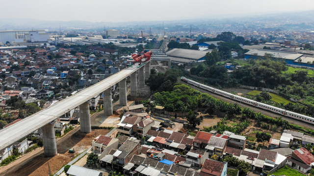 Kereta api melintas di dekat proyek konstruksi kereta api cepat Jakarta-Bandung di Lembah Teratai, Kabupaten Bandung Barat, Jawa Barat, Minggu (8/8/2021). Foto: Raisan Al Farisi/ANTARA FOTO
