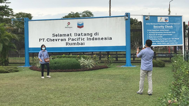 WARGA berfoto dengan latar tulisan Selamat Datang di PT Chevron Pacific Indonesia, Rumbai. 