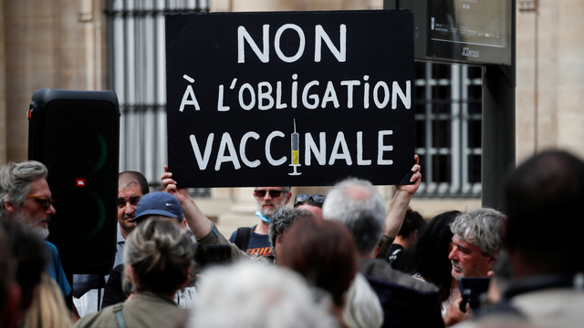 Seorang pengunjuk rasa memegang plakat selama demonstrasi menentang pembatasan Prancis, termasuk health pass di Paris, Prancis, Kamis (5/8). Foto: Benoit Tessier/REUTERS