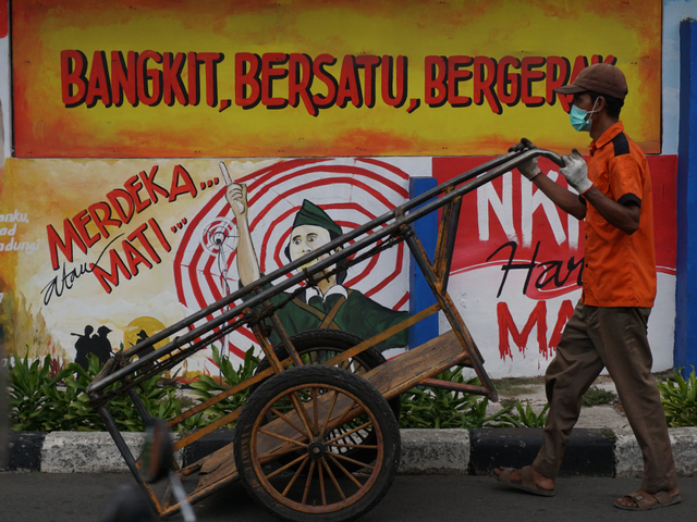 Warga melintas di trotoar dengan latar mural bertema nasionalisme di Galur, Kec. Johar Baru, Jakarta Pusat, Selasa (10/8/2021). Foto: Jamal Ramadhan/kumparan