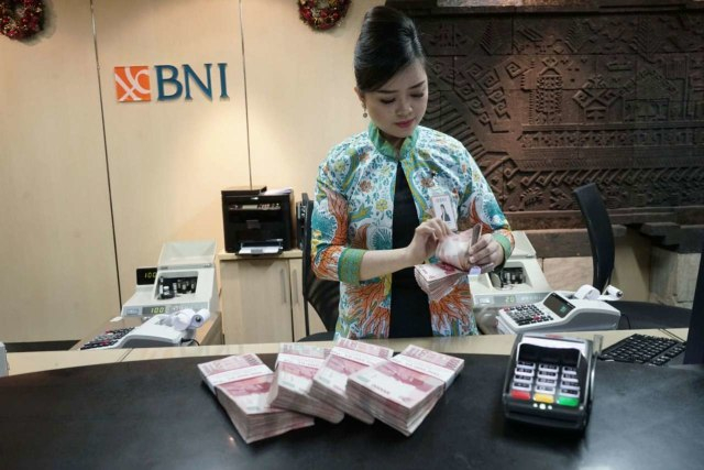 Petugas teller PT Bank Negara Indonesia (Persero) Tbk atau BNI sedang menghitung uang. Foto: Dok. BNI