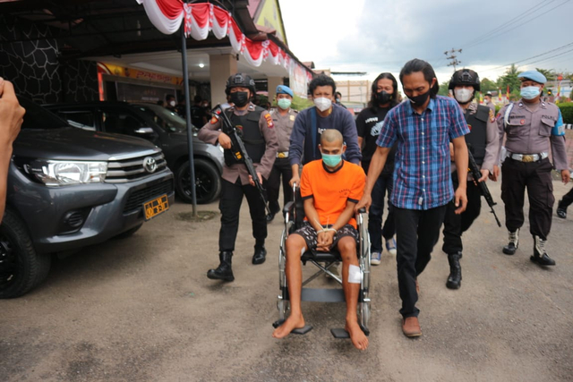 Petugas membantu mendorong kursi roda tersangka RA untuk kembali ke sel usai press release. (Yusrizal/Hi! Pontianak)