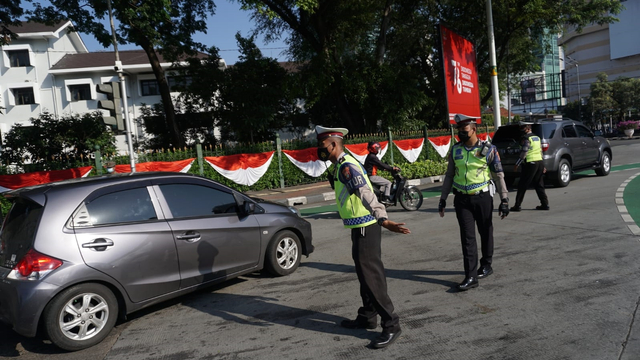 Polisi mengatur lalu lintas saat penerapan Ganjil Genap di Bundaran Senayan, Jakarta, Kamis (12/8). Foto: Jamal Ramadhan/kumparan