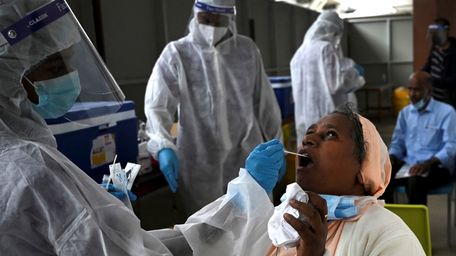 Seorang petugas kesehatan mengumpulkan sampel swab PCR di Chennai, India. Foto: Arun SANKAR/AFP