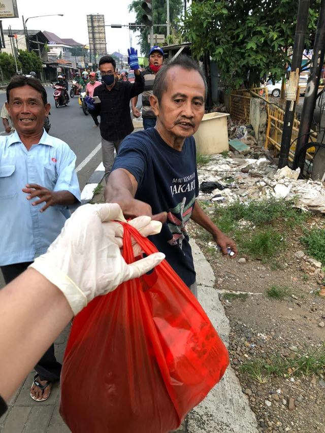 Masyarakat berlarian mengambil sembako hasil donasi Covid-19 yang dilakukan karang taruna RW 013 di daerah Bekasi