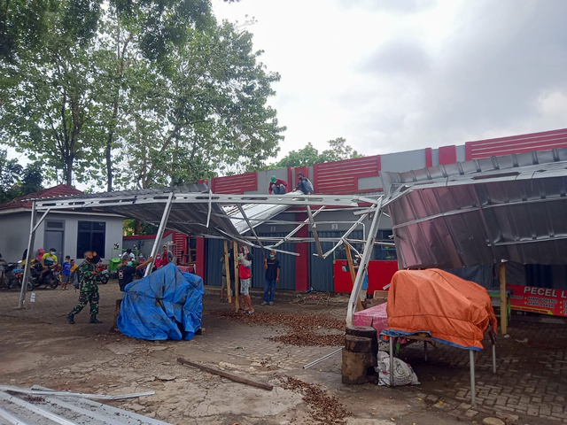 Sejumlah warga dan pedagang membereskan sisa kanopi kios di stadion mini Way Dadi yang rusak akibat hujan deras, Jumat (13/8) | Foto : Sidik Aryono/ Lampung Geh