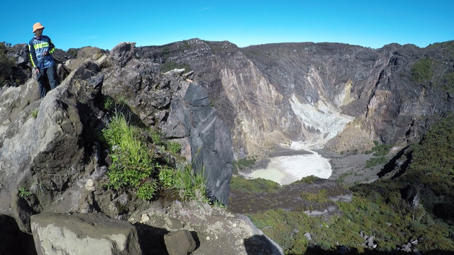 Seorang pendaki berdiri di tubir kawah Ciremai melihat pemandanga kawah ganda Ciremai. Foto: Harley Sastha